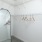 a closet with white walls, hangers, shelves and a mirror