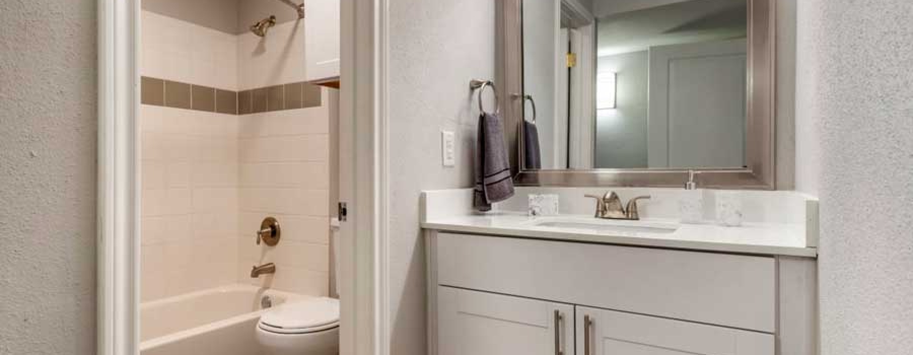 Modern bathroom with a large mirror  at Regency Park Cypress apartments for rent.