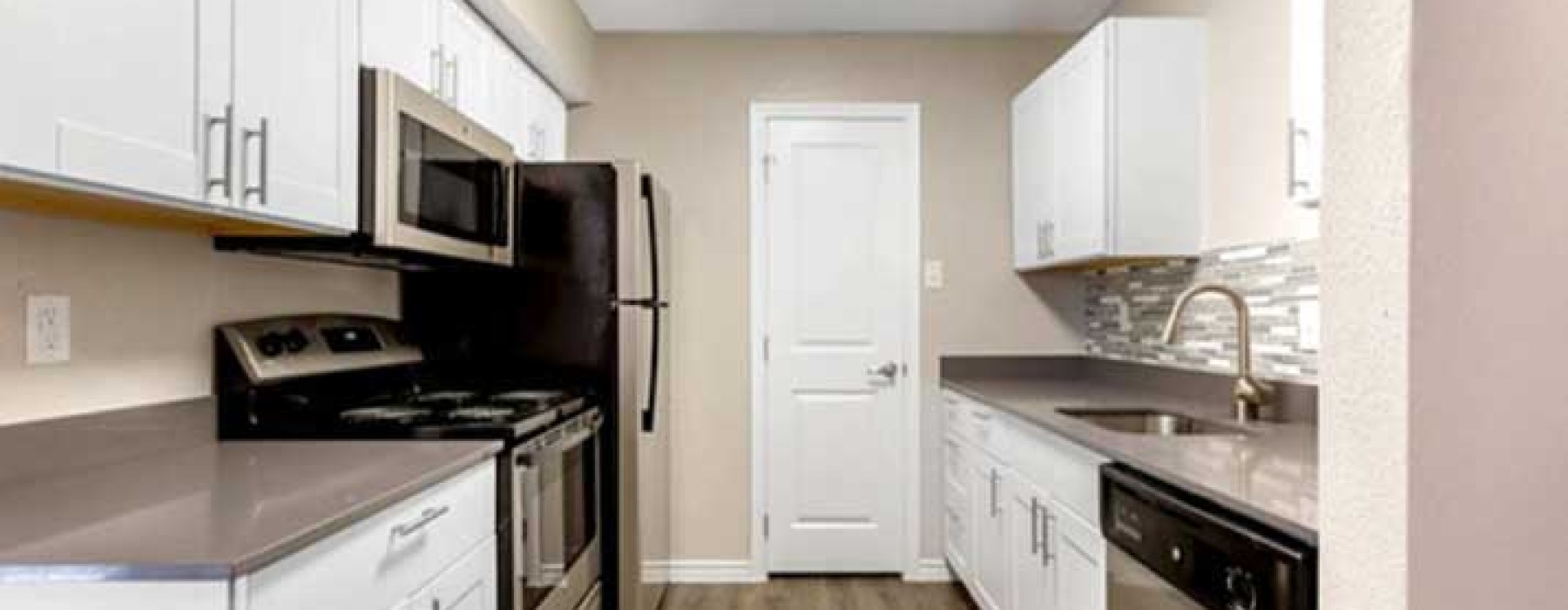 Renovated kitchen with white cabinets inside a Cypress apartment for rent at Regency Park,
