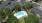 a swimming pool surrounded by trees and buildings